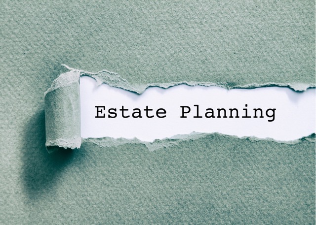 ripped green paper revealing words estate planning