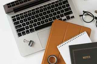 laptop notebooks and other items on a white desk